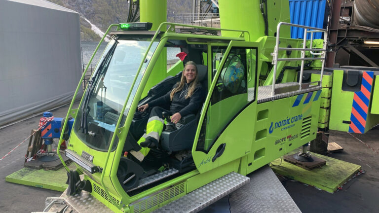 Female crane operator in a green mobile crane from supplier Nordic Crane